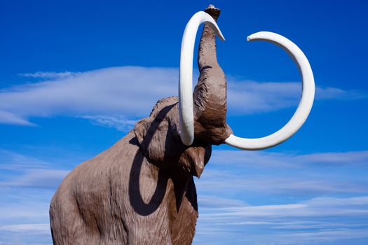 Sculpture of extinct woolly mammoth in aggressive pose.
