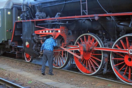 Man doing the repair on the old steam locomotive
