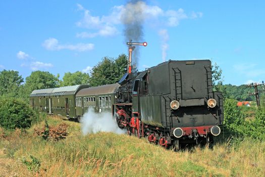 Old retro steam train passing through polish countryside

