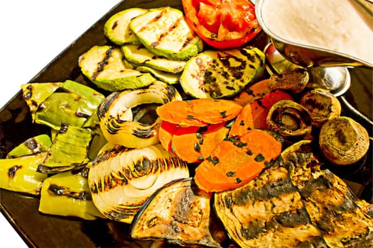 Grilled vegetables with milk sauce, isolated on white background.