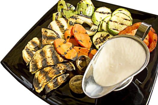 Grilled vegetables with milk sauce, isolated on white background.