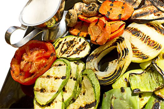 Grilled vegetables with milk sauce, isolated on white background