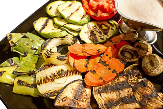 Grilled vegetables with milk sauce, isolated on white background