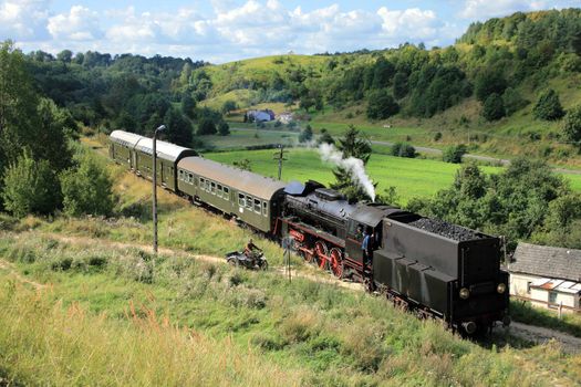 Beautiful hilly landscape with an old retro steam train
