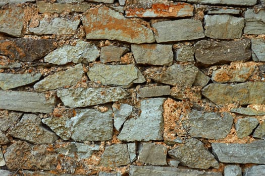 Detail of multicolor stone wall with coarse formless colored stones