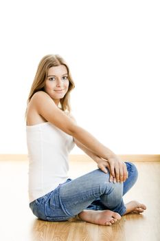 Portrait of a sexy young woman sitting on floor isolated over white background