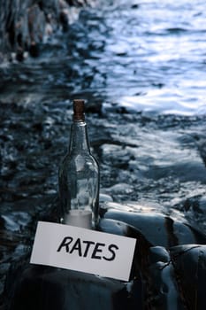 a bottle with a message on water rates standing on a rocky coastline