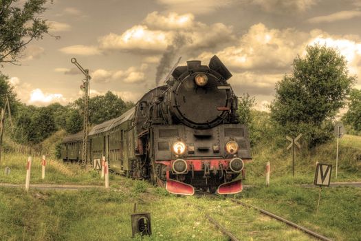 Old retro steam train passing through polish countryside
