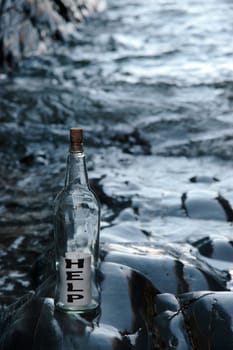 a bottle with a help message standing on a rocky coastline