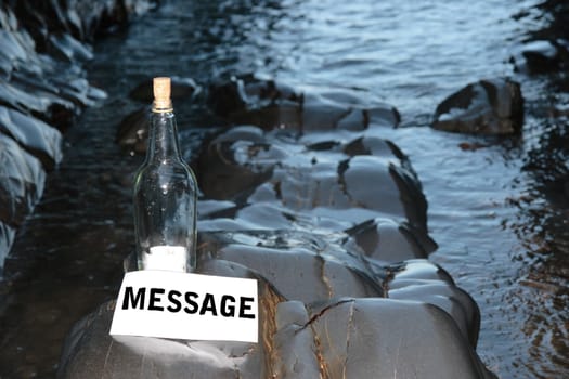 a bottle with a message standing on a rocky coastline