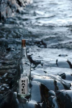 a bottle with a message on water rates standing on a rocky coastline