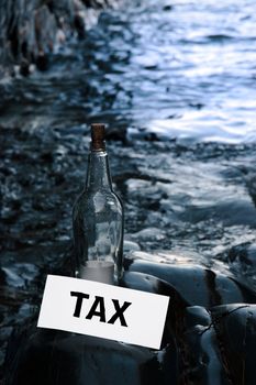 a bottle with a message on water taxes standing on a rocky coastline