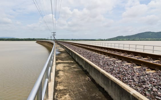 Railroad tracks curving  across the lake