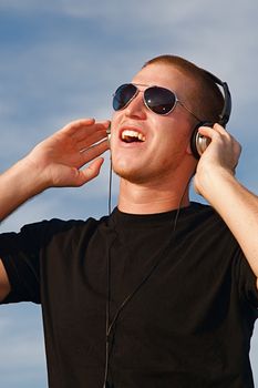 A cool young man listens to music on some headphones