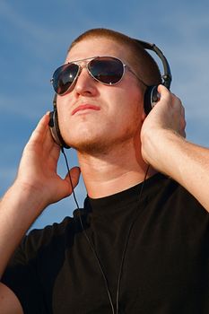 A cool young man listens to music on some headphones