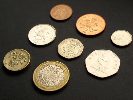 British Pounds coins (UK currency) over a dark background