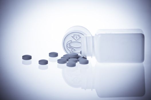 Pills near vintage bottle isolated on white