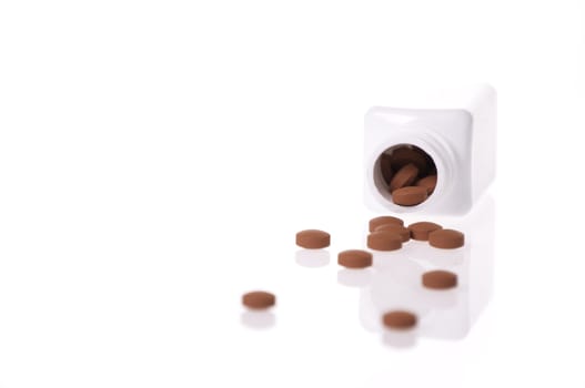 A white pill bottle with red generic pills  on a white background.