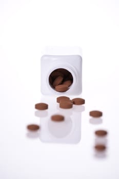 A white pill bottle with red generic pills  on a white background.