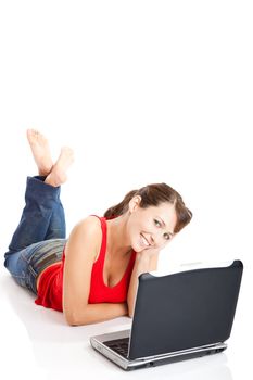 Beautiful and happy young woman lying on floor and working on a laptop