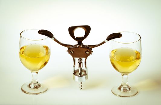 Glass of white wine and corkscrew isolated on a white background