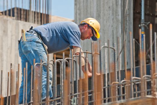 Authentic construction worker busy on the positioning of formwork frames in construction site