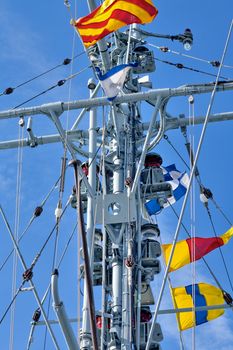 Frigate with signal flags against the blue sky