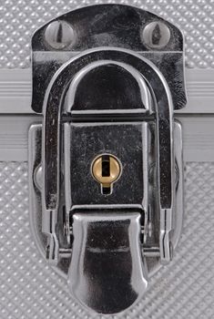 Shiny metal case lock closeup.