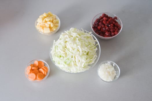 Five bowls with chopped vegetables, ingredients for vegetable soup