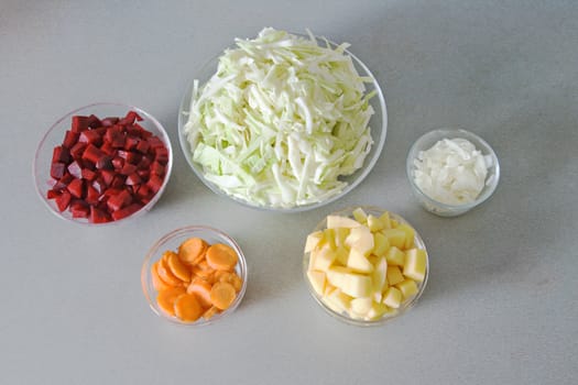 Five bowls with chopped vegetables, ingredients for vegetable soup