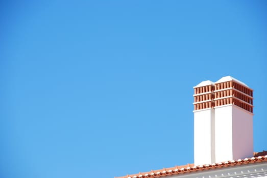 two traditional chimneys on blue sky background