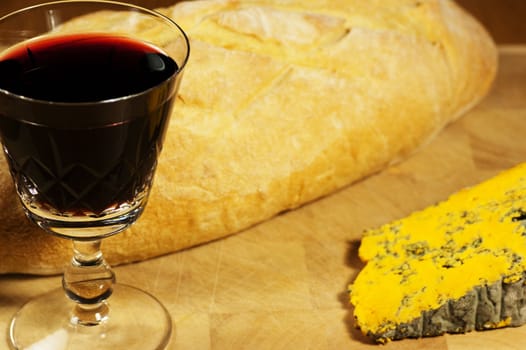 A glass of red wine with bread and cheese