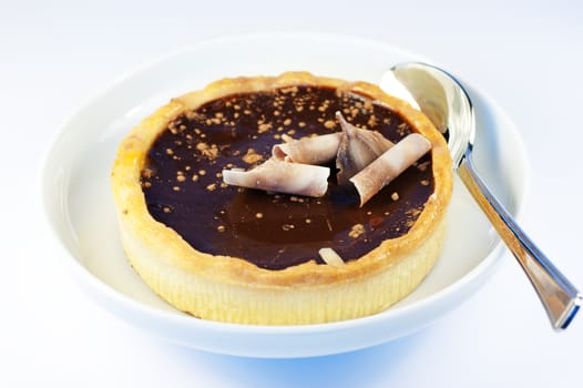 A rich dark chocolate tart with a silver spoon