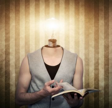 Young male reading a book with a light bulb  instead of head