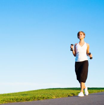 Young woman walking with weights, from a complete series of photos.