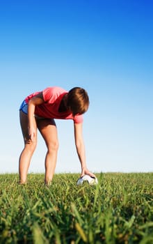 Young woman playing soccer in a field, from a complete series of photos.