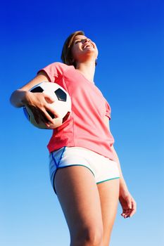 Young woman playing soccer in a field, from a complete series of photos.