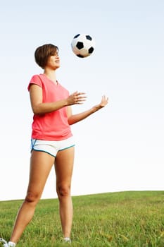 Young woman playing soccer in a field, from a complete series of photos.