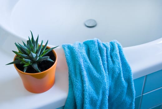 Detail of bathroom with towel in white, orange and azure blue