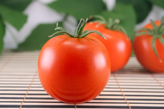 Three tomatoes removed on a striped bamboo napkin