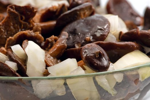 Salted mushrooms with sliced onion and olive oil in glass bowl 