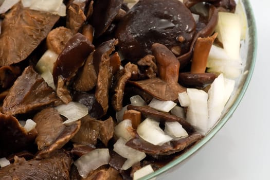 Salted mushrooms with sliced onion and olive oil in glass bowl 