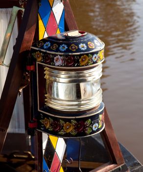 Canal life in England with traditionally decorated lamp on display