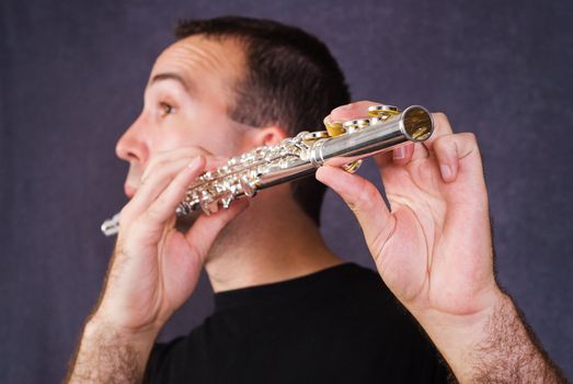 Closeup view of a young male playing his wind instrument