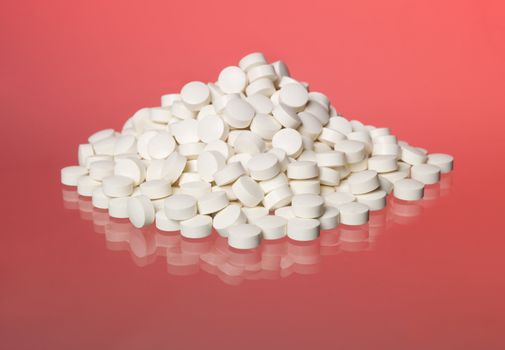 Stack of pills towards red background