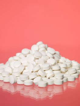 Stack of pills towards red background