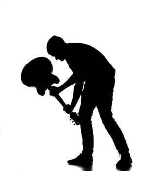 silhouette of a man smashing his guitar