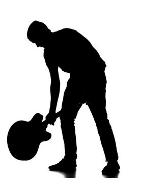 silhouette of a man smashing his guitar