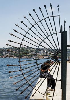 creative shot of Istanbul fishermans wharf and quayside through crescent railings, portrait, crop space