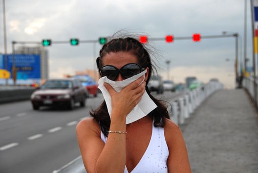 A girl with a napkin trying to bear the hot and the pollution of Thailand Capital